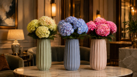 Artificial hydrangeas in green, blue and pink displayed in three decorative vases