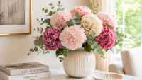 Kunsthortensien in Rosa, Creme und Beerentönen mit Eukalyptus in einer geriffelten Keramikvase