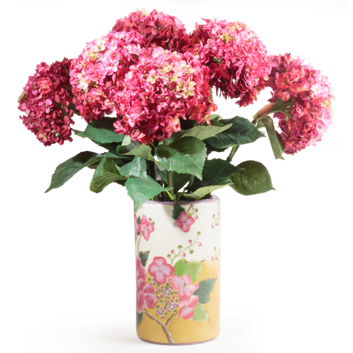 Plusieurs hortensias artificiels roses présentés dans un vase décoratif