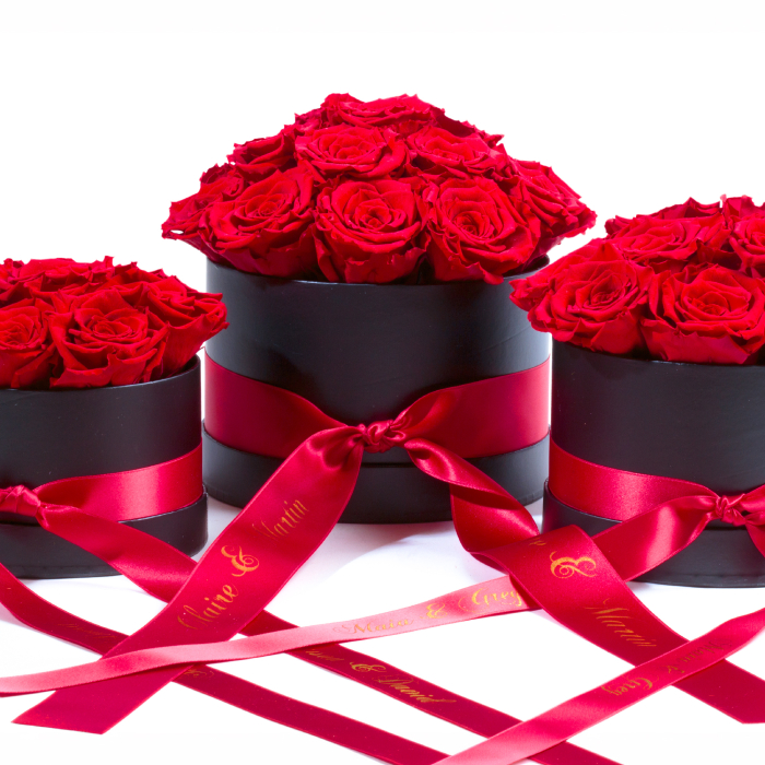 Nahansicht personalisierte Rosenboxen in S, M und L mit roten Infinity Rosen und rotem Satinband