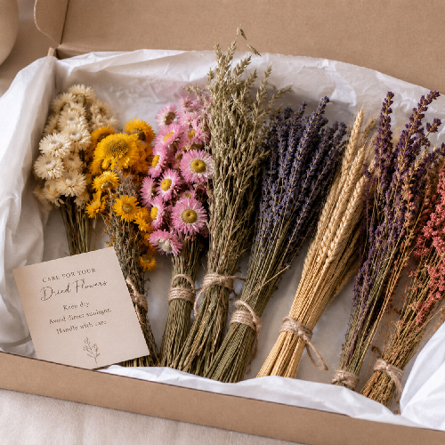 Bundles of dried flowers carefully stored in tissue paper inside a cardboard box