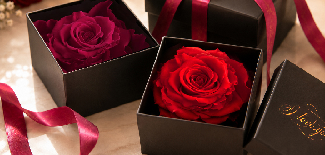 Red and burgundy preserved roses in individual black gift boxes