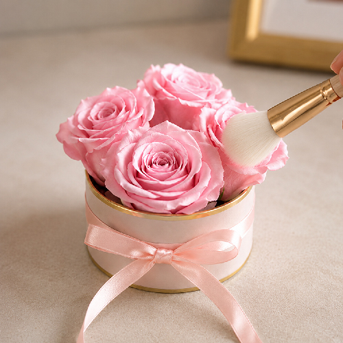 Soft brush gently removing dust from pink preserved roses in a rose box
