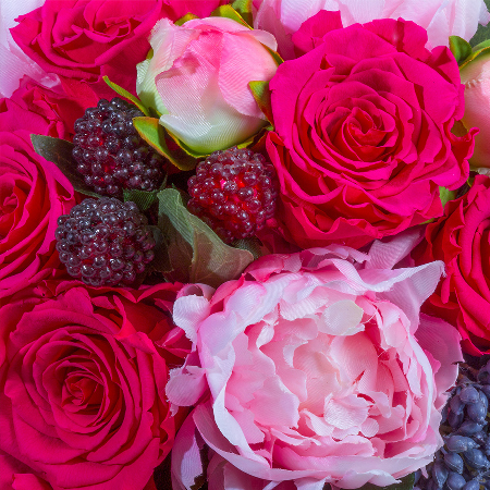 Detailaufnahme mit pinken Infinity Rosen, künstlichen Pfingstrosen, grauvioletten Blüten, Beeren und konserviertem Efeu