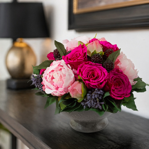 Langlebiges Blumengesteck mit Infinity Rosen und Pfingstrosen als Dekoration auf einem modernen Sideboard