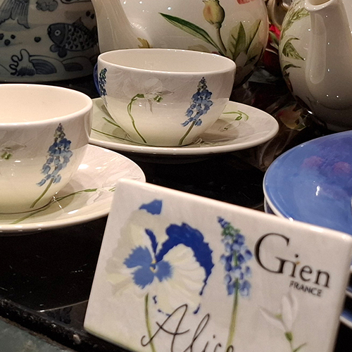 Tassen, Untertassen und Kanne aus Gien-Porzellan mit blauem Blumen- und Pflanzenmotiv