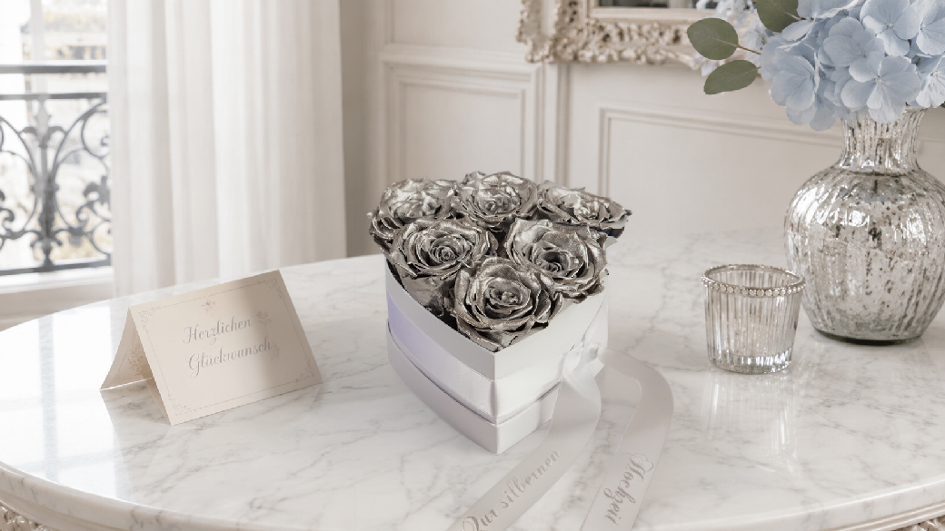 Silberfarbenes Rosenherz zur Silbernen Hochzeit mit sechs Infinity Rosen und weißem Satinband